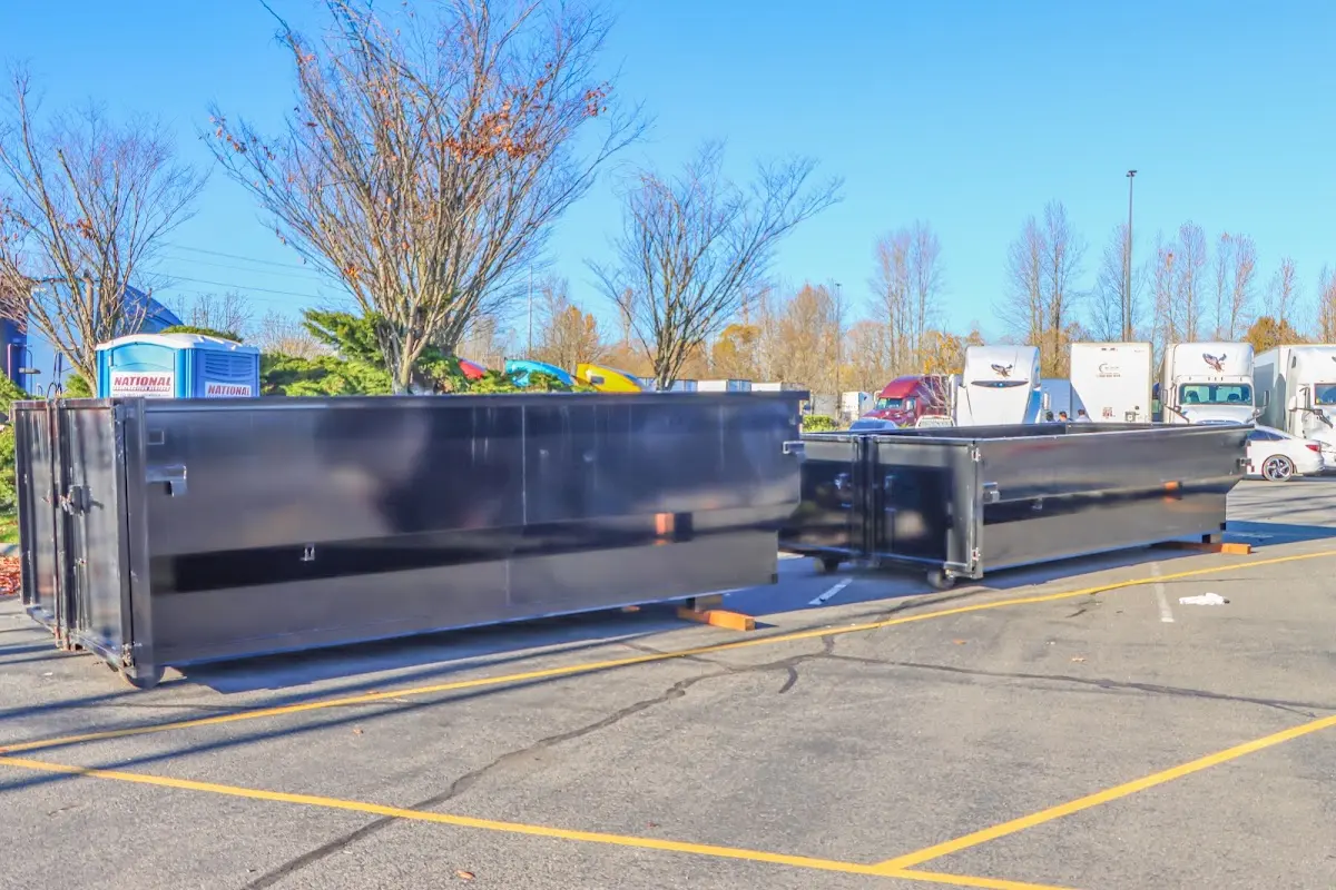 Professional dumpster rental service with roll-off container on residential driveway in Jackson